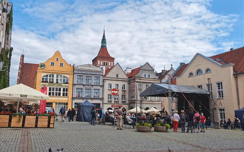 22 - The historic Old Town Market Square in Olsztyn, Poland, featuring colorful traditional tenement houses and a prominent church tower in the background